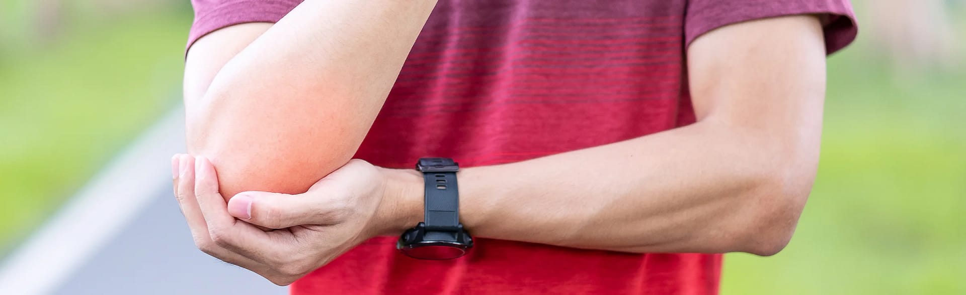 Man holding elbow after a sporting injury