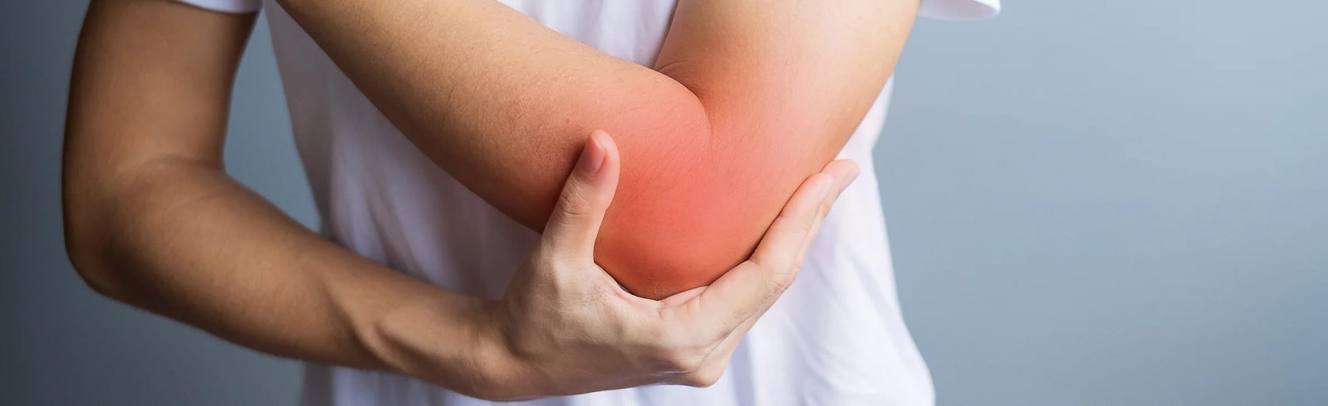 Male holding his elbow which is highlighted to show pain as he is suffering from golfers or tennis elbow